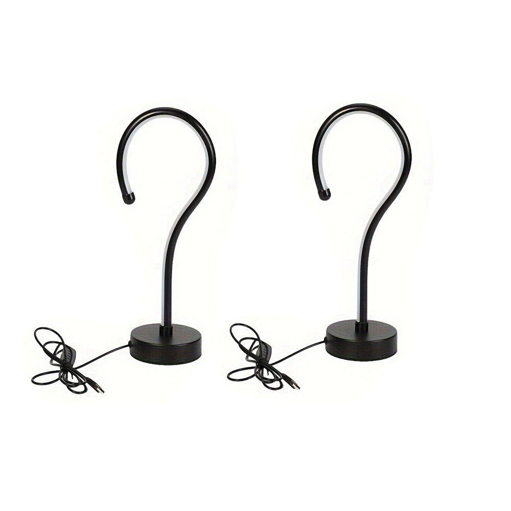 Two black metal hooks on stands with wires on a white background