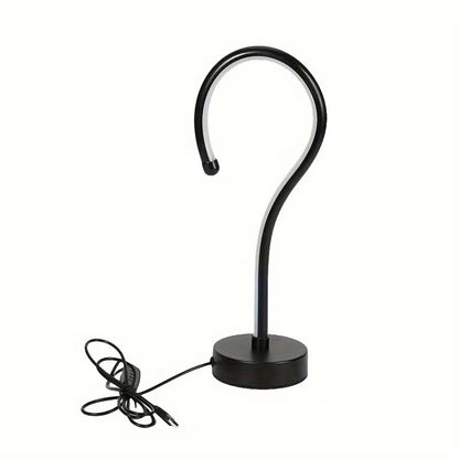 Black curved lamp with base on a white background